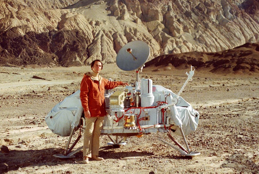Sagan beside a model of the Mars lander.