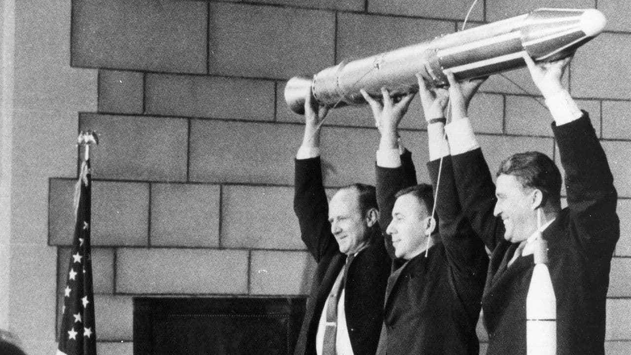 Pickering, Van Allen, and von Braun holding a model of Explorer 1 over their heads