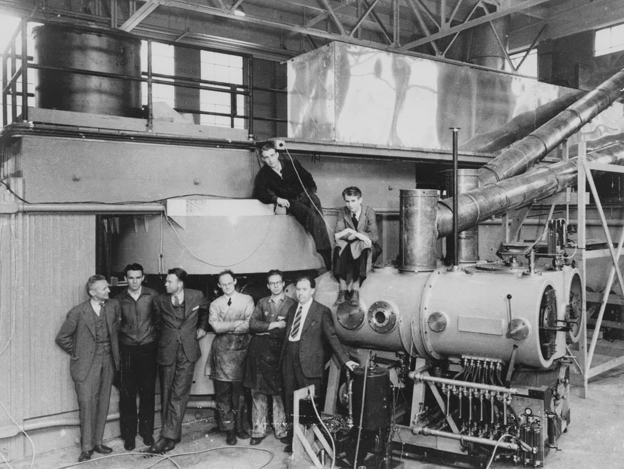 Ernest Lawrence's Berkeley team gathered around the large cyclotron magnet