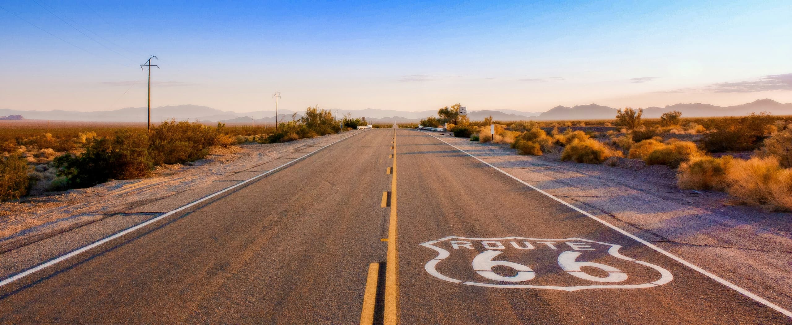 A gallery image from Iconic Symbols: Route 66 Shield Painted On Desert Highway At Sunrise