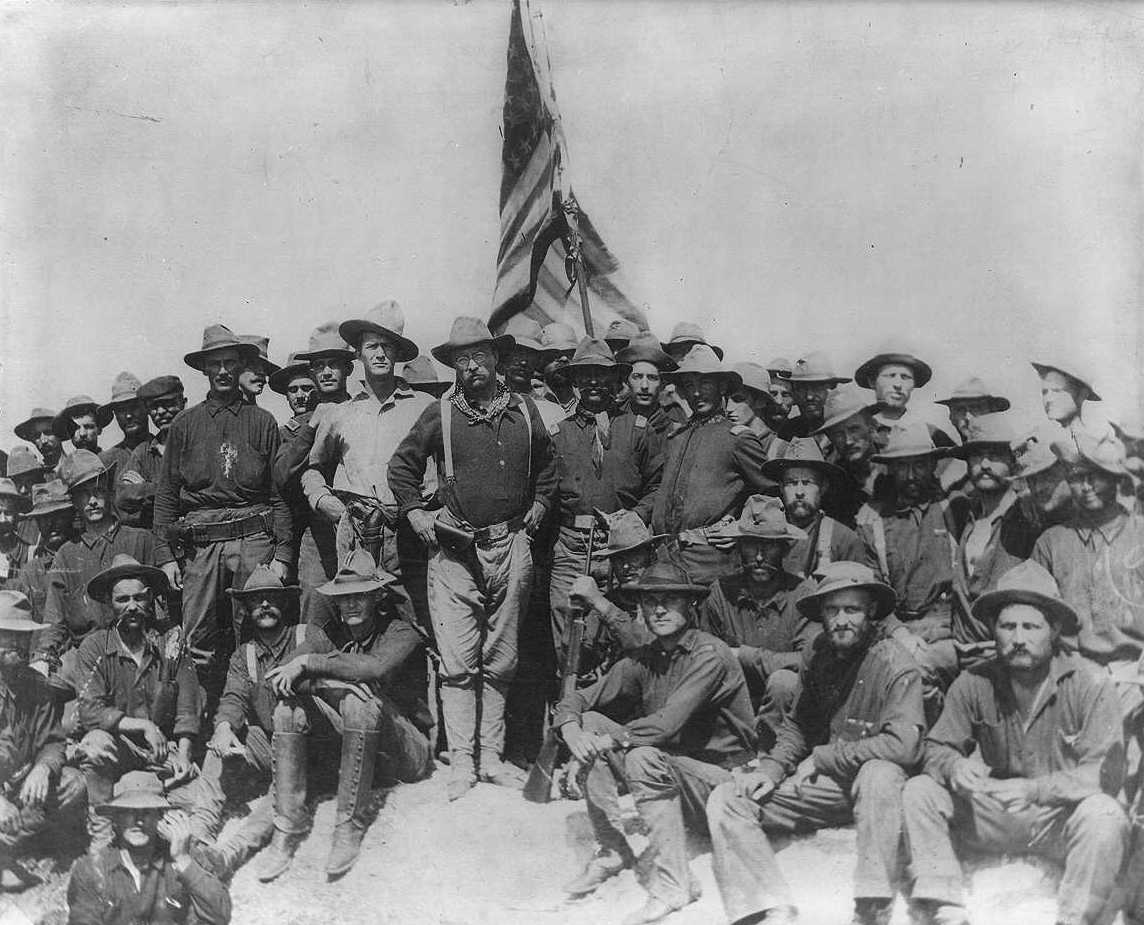 Theodore Roosevelt with the Rough Riders and the U.S. flag after the charge up San Juan Hill