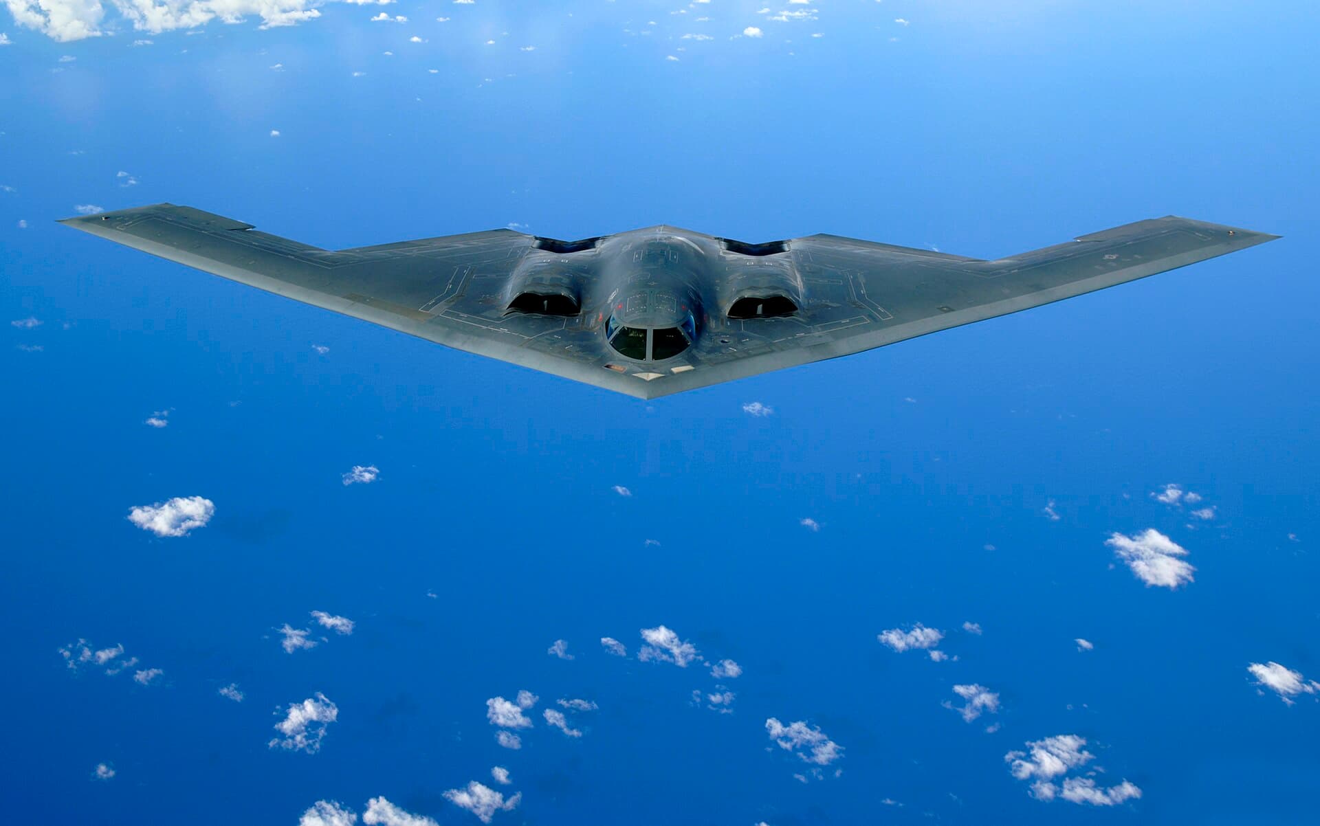 A B-2 Spirit flying-wing stealth bomber in flight above the ocean