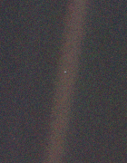 Earth as a single pale dot suspended in a band of scattered sunlight