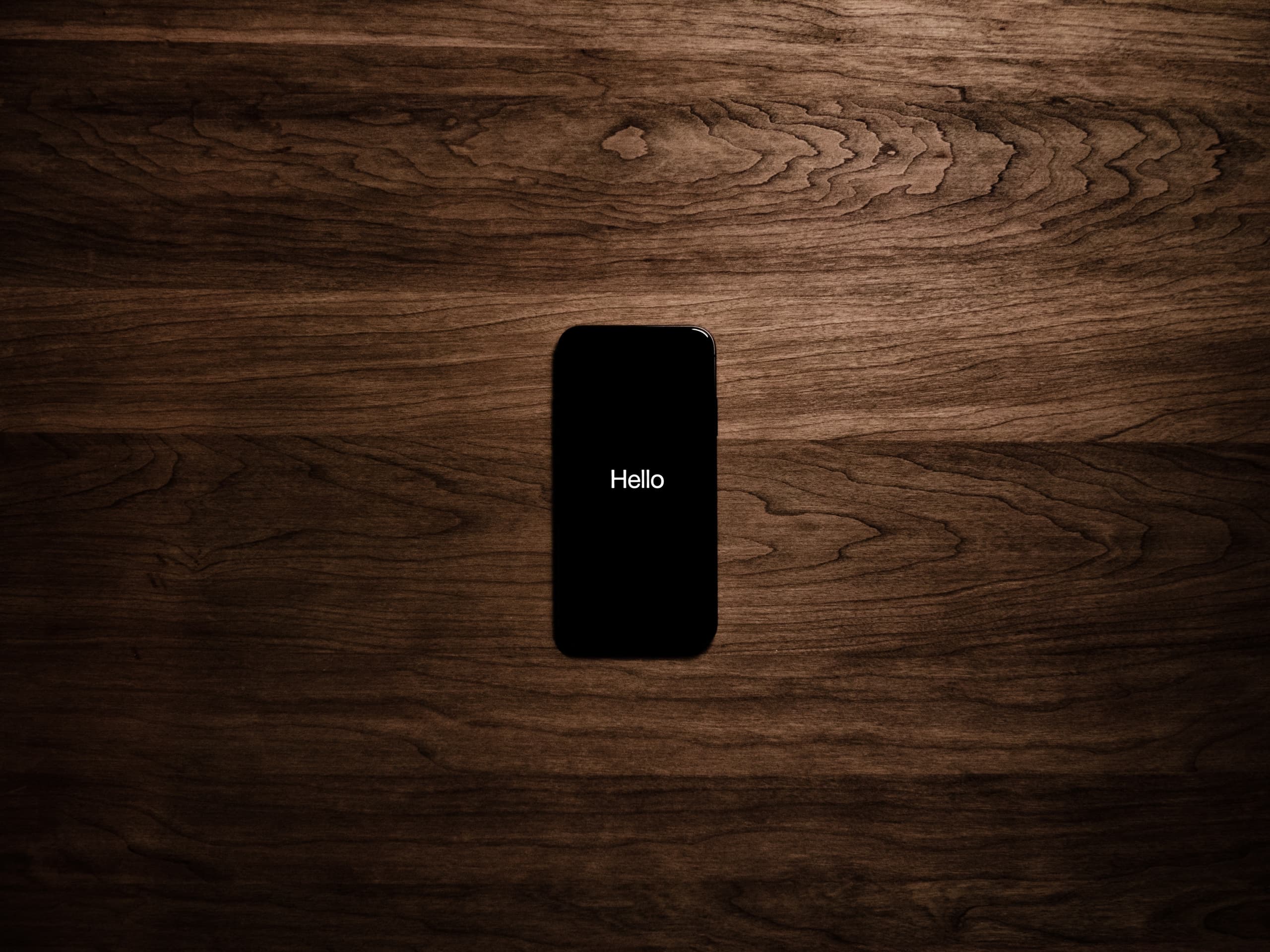 A gallery image from Technology: IPhone Saying Hello On Wooden Background