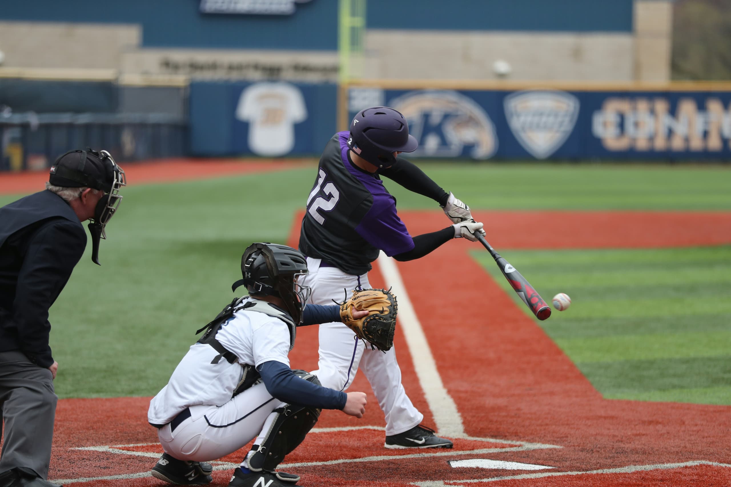 Baseball batter swinging at pitch with catcher and umpire