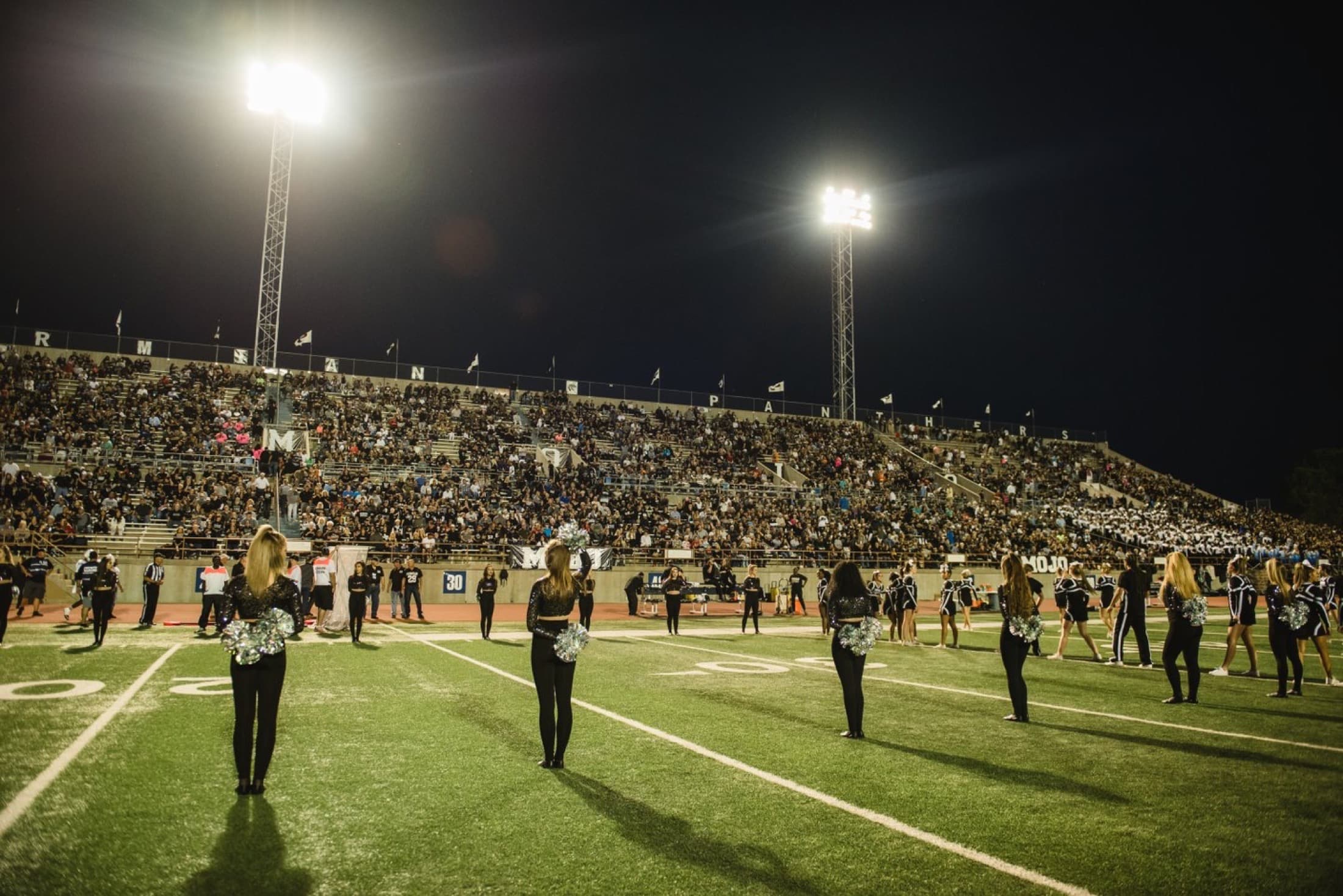 A Friday-night high school football stadium under the lights