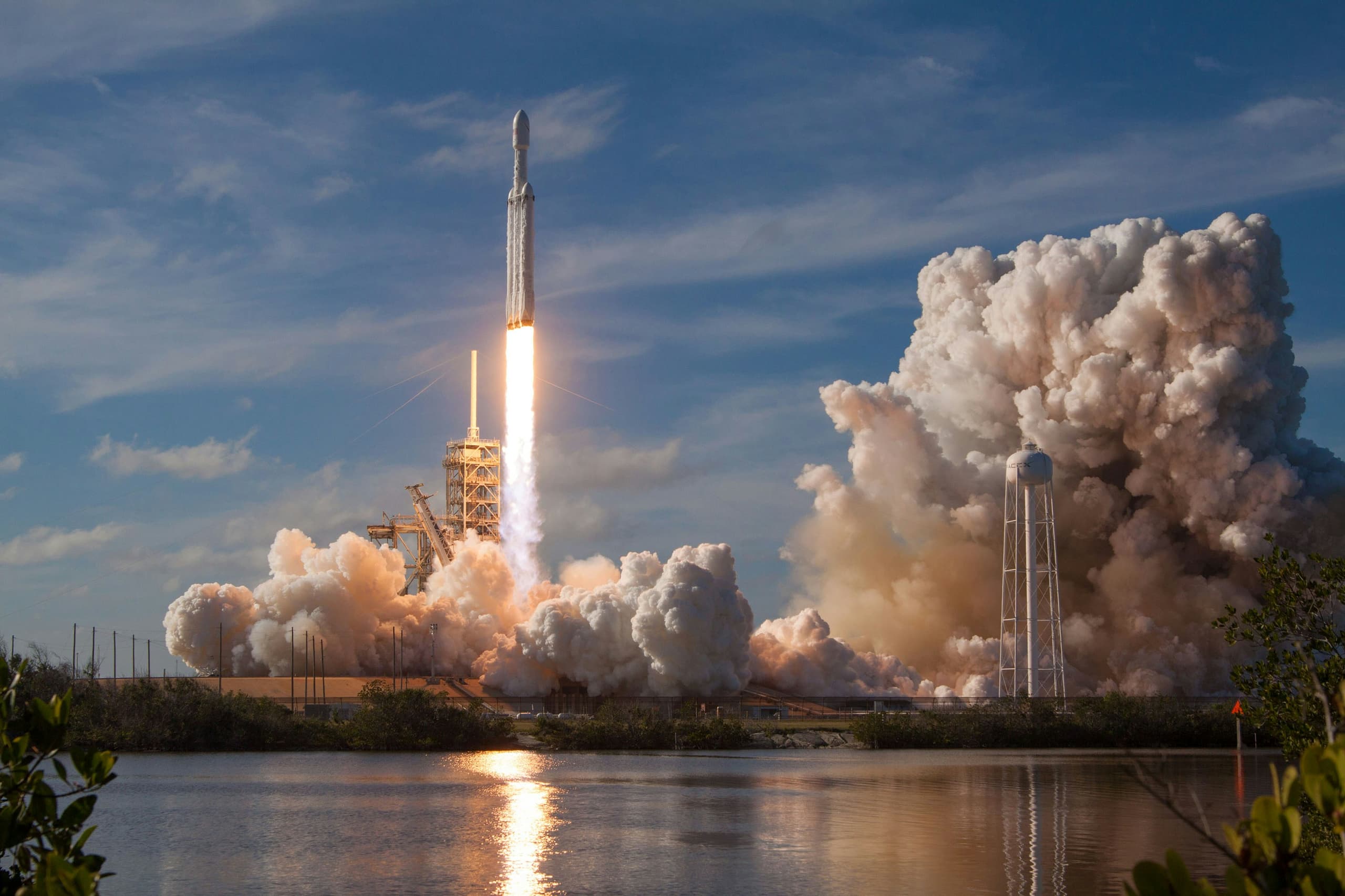 A SpaceX rocket lifting off in a plume of fire and smoke against the sky