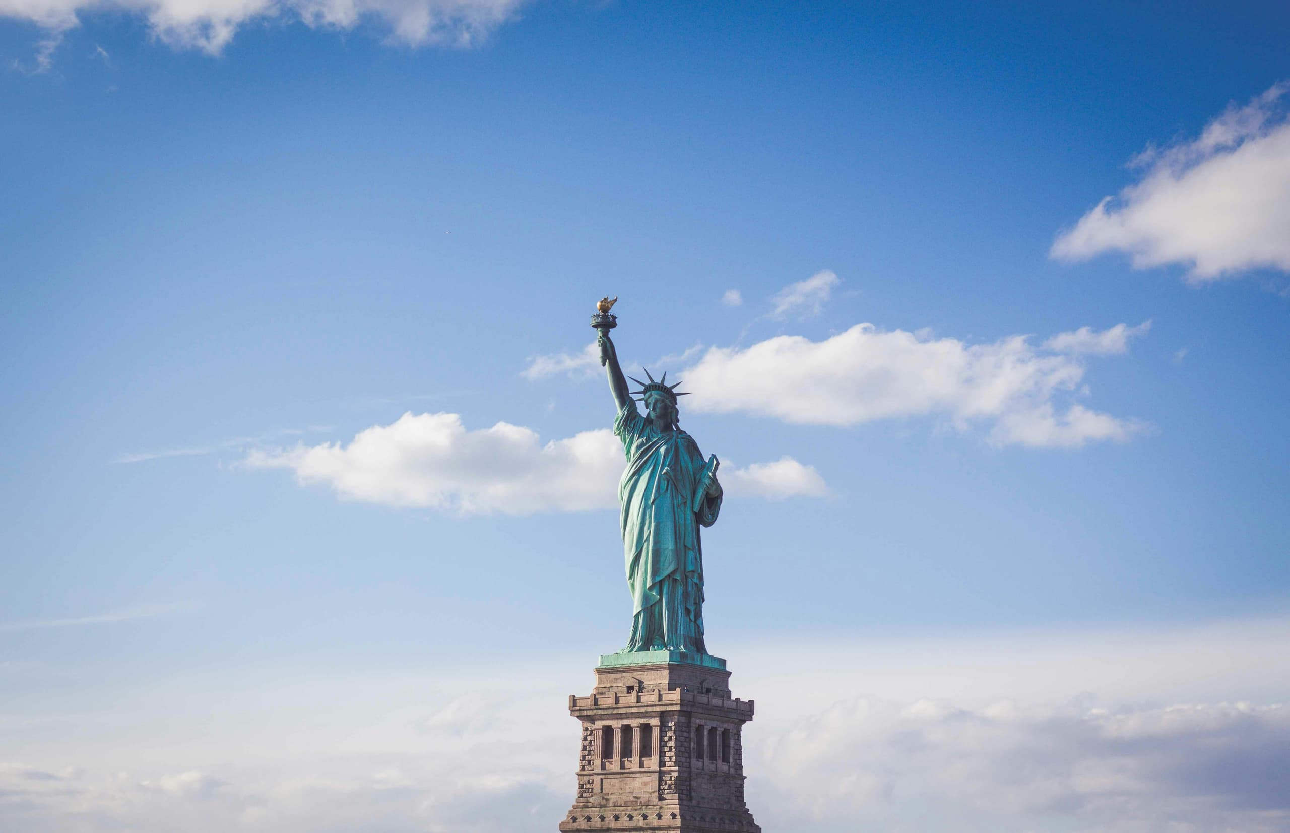 Statue of Liberty viewed in clear daylight against a bright blue sky
