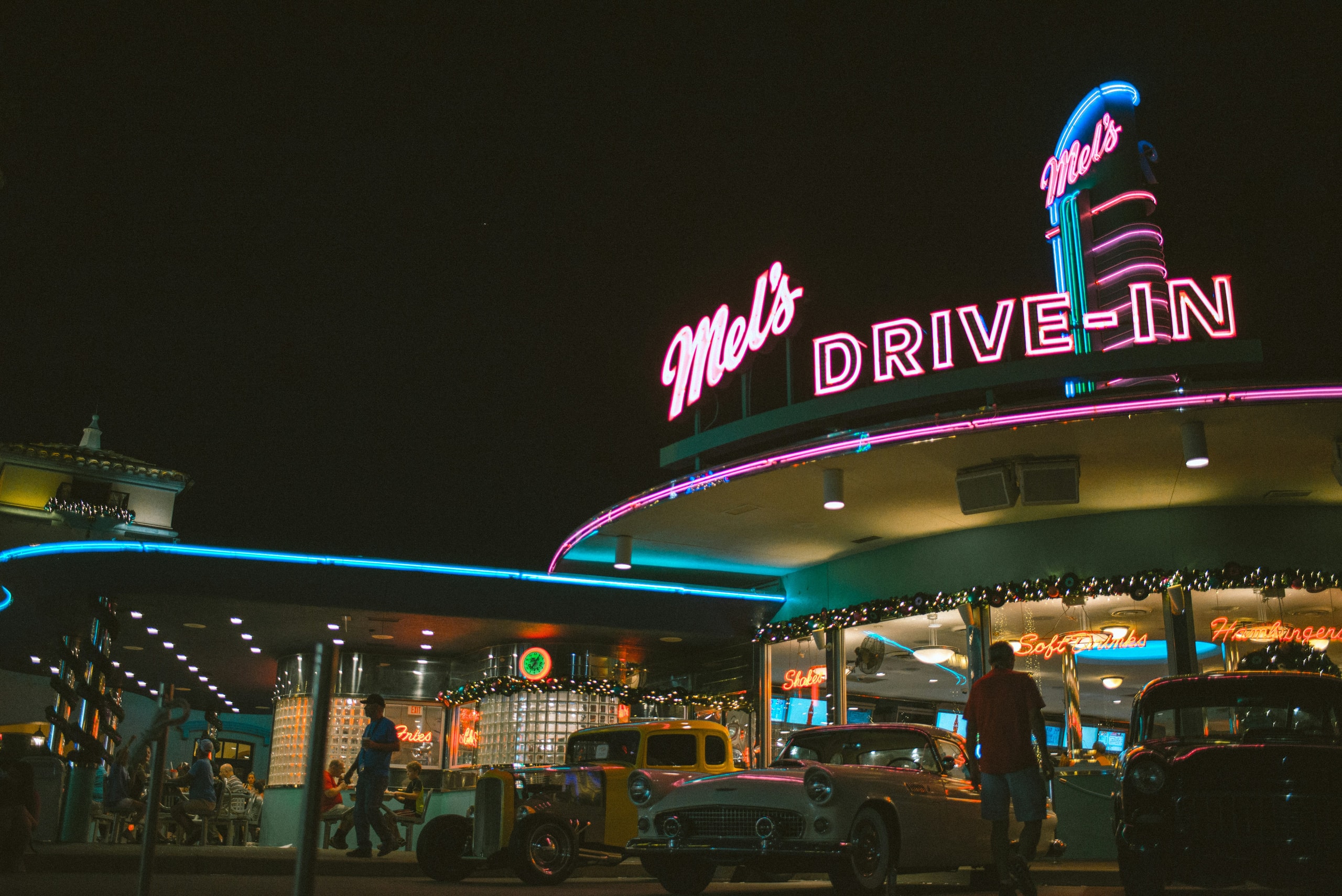 Vintage Classic Cars parked outside Mel's Drive-In retro diner at night